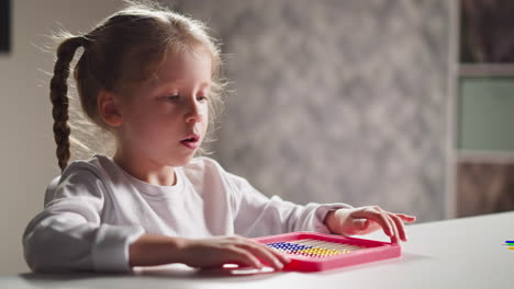 Girl-student-plays-with-colorful-abacus-sitting-at-table