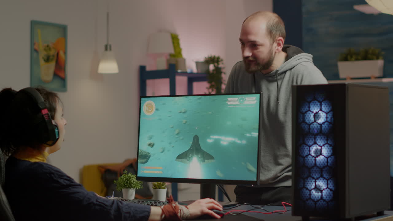 hombre nervioso gritando a la mujer mientras ella está jugando un videojuego de disparo espacial