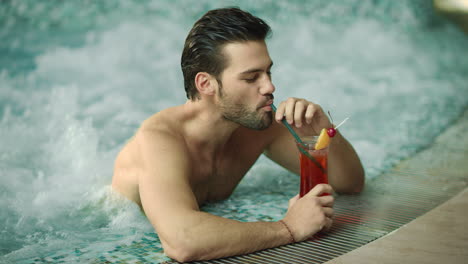 Closeup-sexy-man-drinking-cocktail-at-luxury-pool.-Handsome-guy-drinking-alcohol