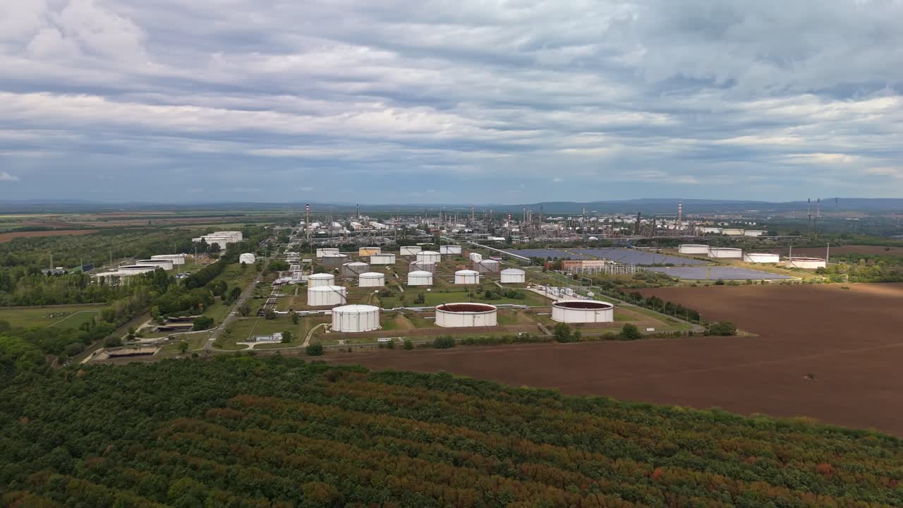 Reversing drone view of the Mol Danube Oil Refinery in Százhalombatta, Hungary, with its industrial facilities and storage tanks