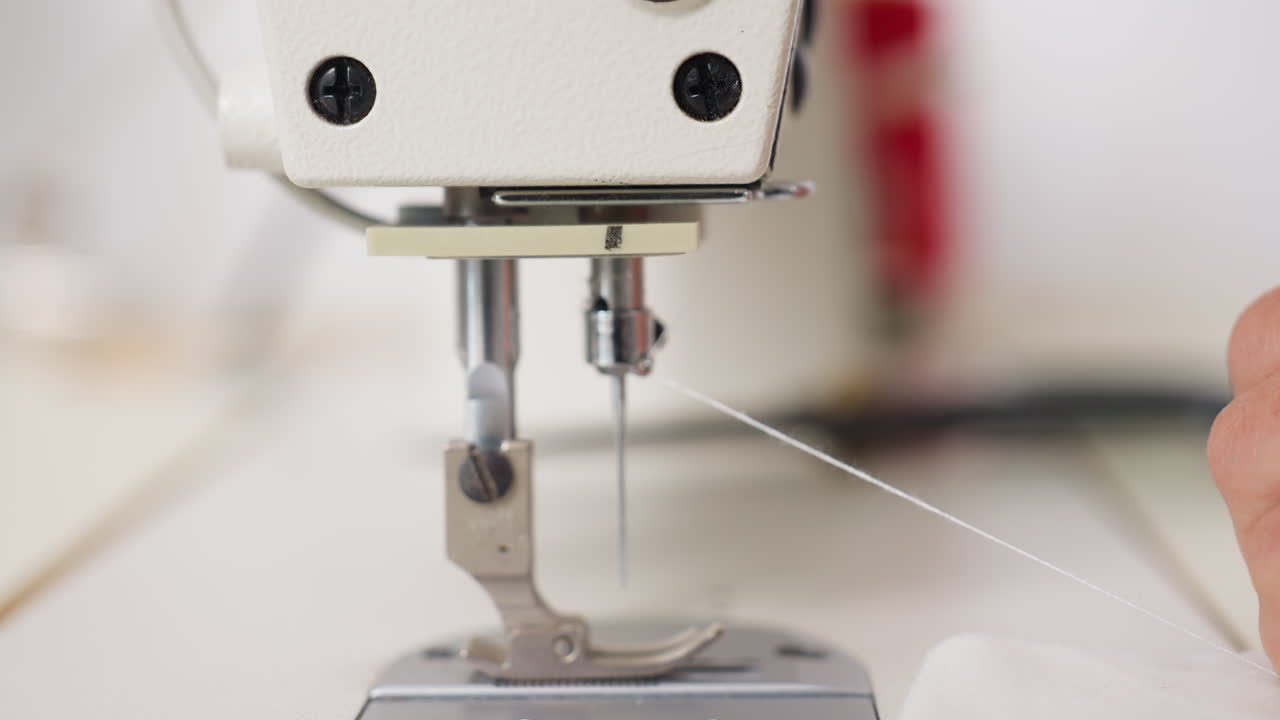Close up view of industrial sewing machine with needle and thread, showcasing stitching gear, capturing tension, mechanical precision, advanced design for garment production in minimal environment
