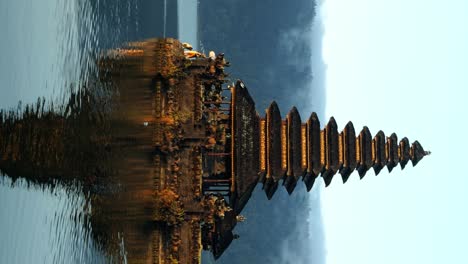 vertical slow motion ascending shot of the pura segara ulun danu batur on the summer trip through bali indonesia at the volcanic lake batur during a sunny morning