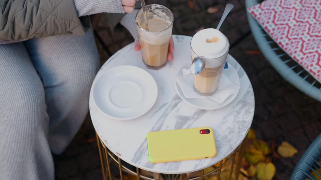 mujer disfrutando de un latte al aire libre en otoño