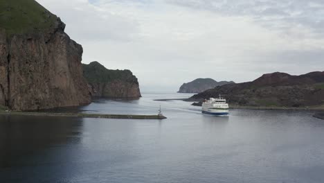 ferry arrives in vestmannaeyjar inlet enclosed by amazing rocky cliffs, heimaey