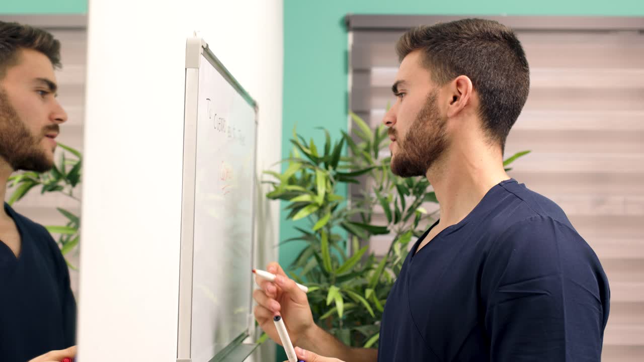 Young Professional Man Writing on Whiteboard