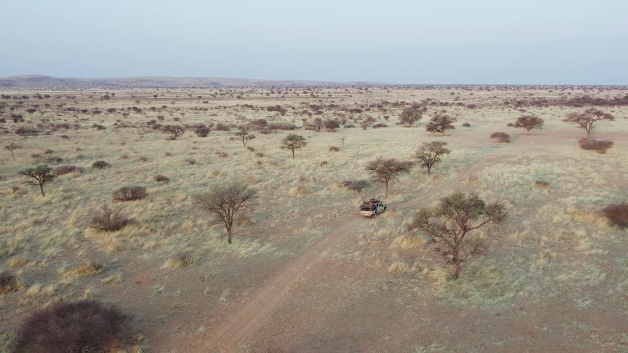 amplia órbita aérea sobre safari jeep conduciendo turistas, namibia, áfrica
