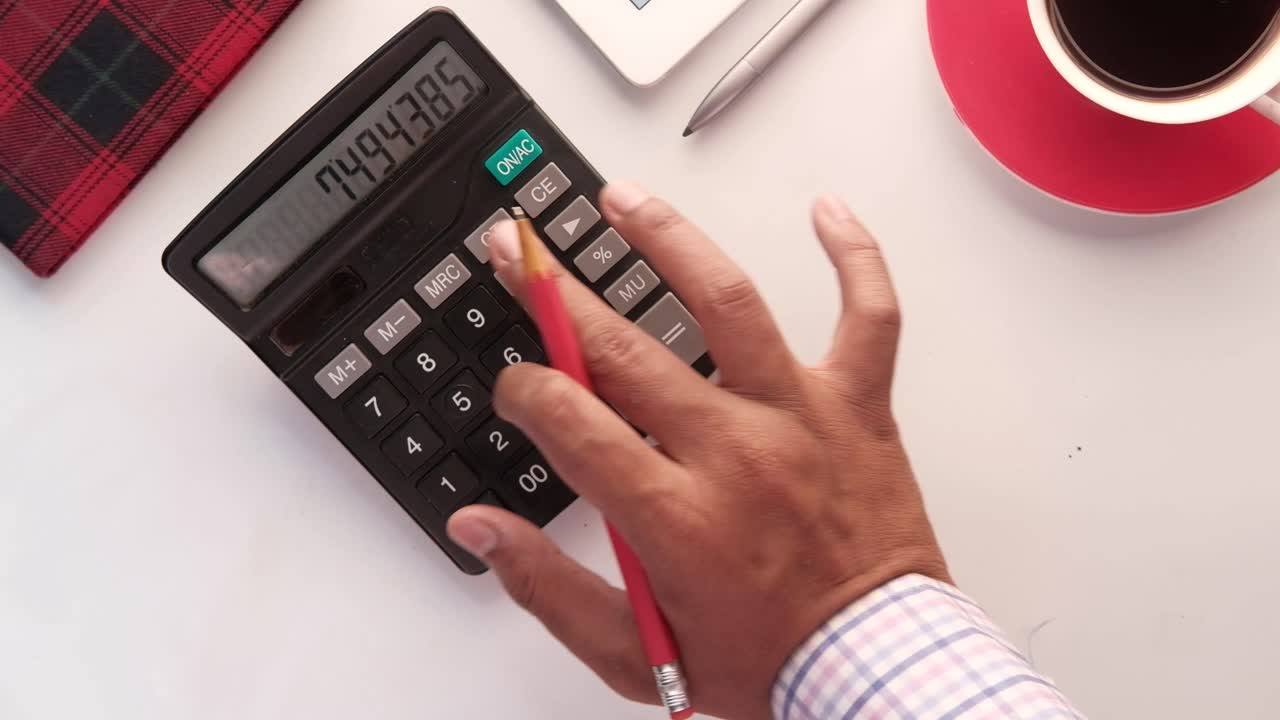 persona usando una calculadora en un escritorio