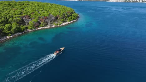 aerial tracking, boat sailing near the pakleni islands, surrounded by turquoise waters and lush greenery in open waters
