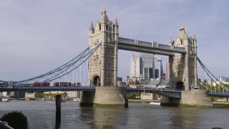 panning to tower bridge below view in clear sunny day with car traffic and tourists