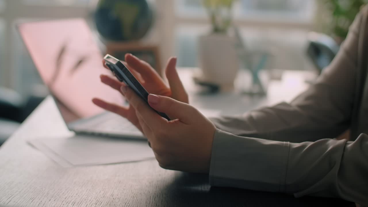 Woman using smartphone at office desk