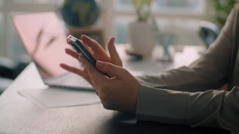 woman using smartphone at office desk