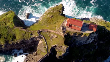 Aerial-gaztelugatxeko-hermitage-on-rock-cliff-formation-with-old-stone-bridge-for-piligrimage