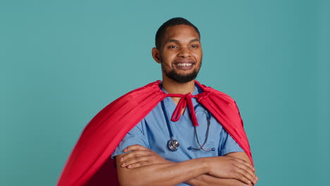 Smiling-male-nurse-portraying-superhero-wearing-red-cape