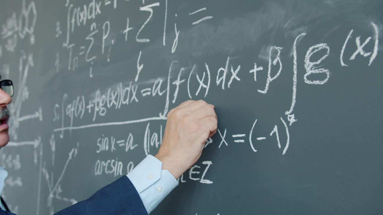 Professor writing equations on a chalkboard