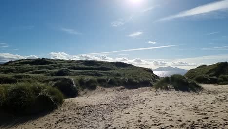 Nebliger-Snowdonia-Berggipfel-Zwischen-Grasbewachsenen,-Sonnenbeschienenen-Goldenen-Sanddünen-Im-Norden-Von-Wales