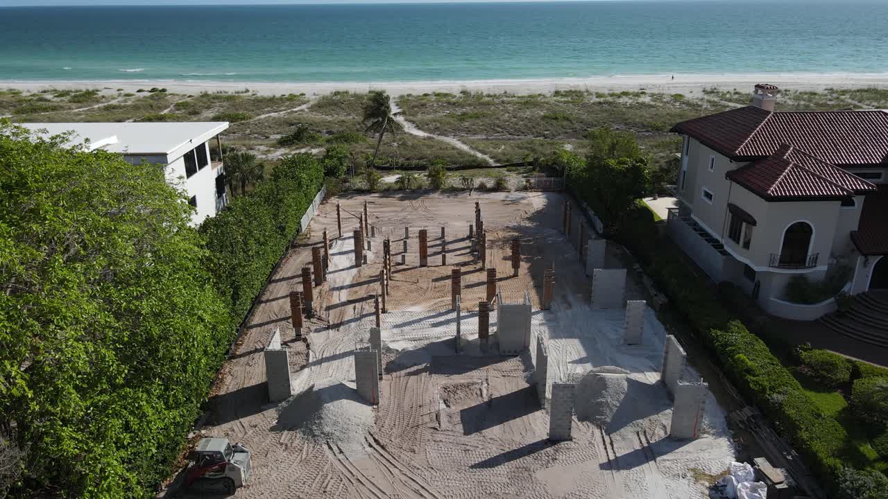 Ripresa aerea bassa e lenta della costruzione di una casa sulla spiaggia in Florida