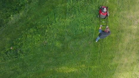 person using a lawnmower on a grassy lawn