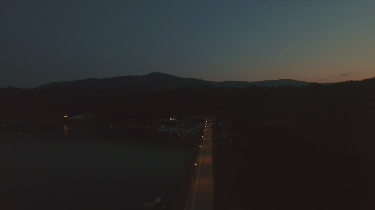 Road With Street Lights By Zlatibor Lake in Cajetina Serbia in The Evening, Aerial Forward Slow