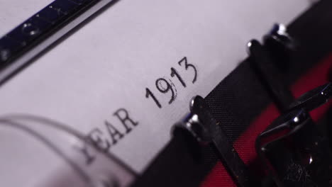 year 1913, typing on white paper in vintage typewriter, macro close up