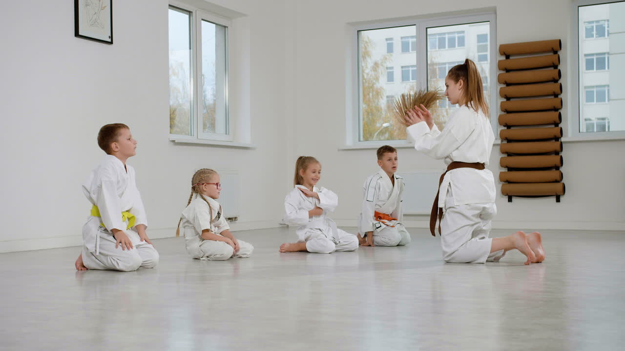 무술 수업에서 바닥에 무을 고 있는 아이들