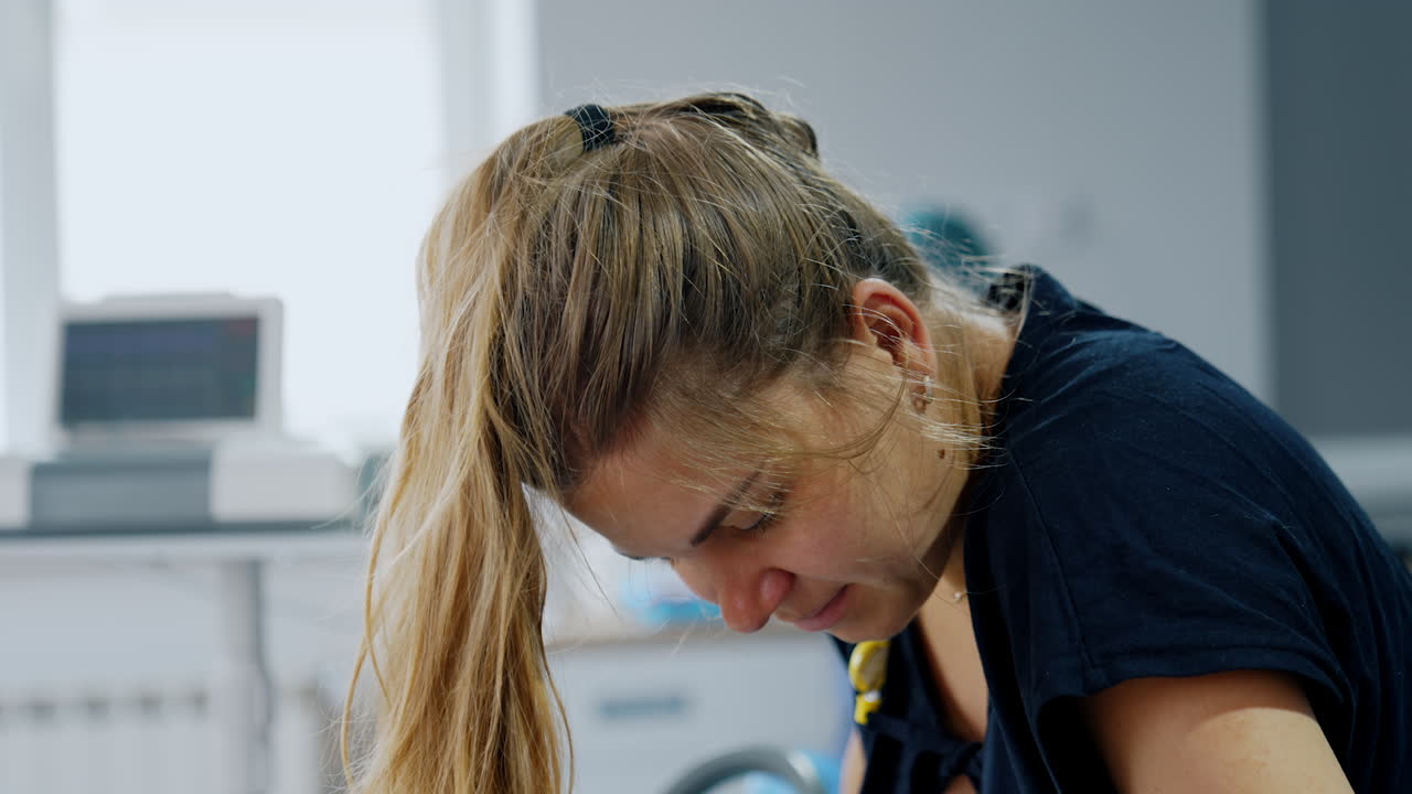 Caucasian long-haired woman stands bending her head ahead. Pregnant lady delivering a baby in clinics.