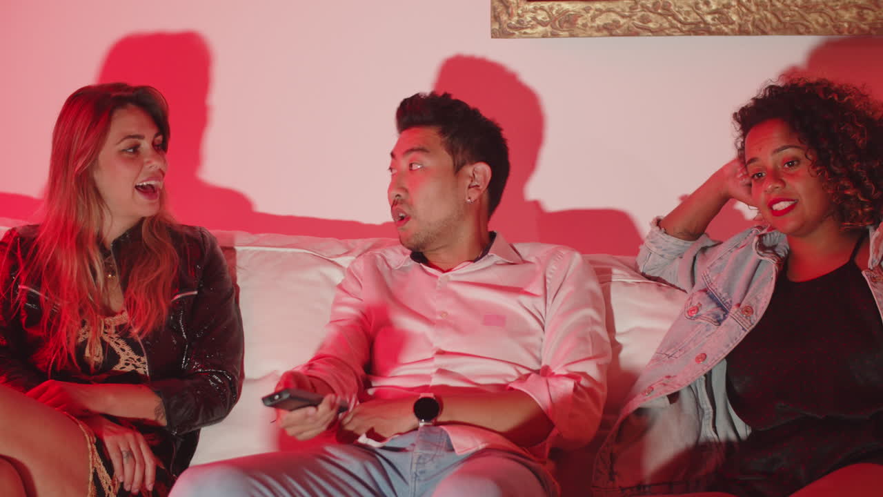 chico y chicas viendo la tv en la sala de estar y hablando