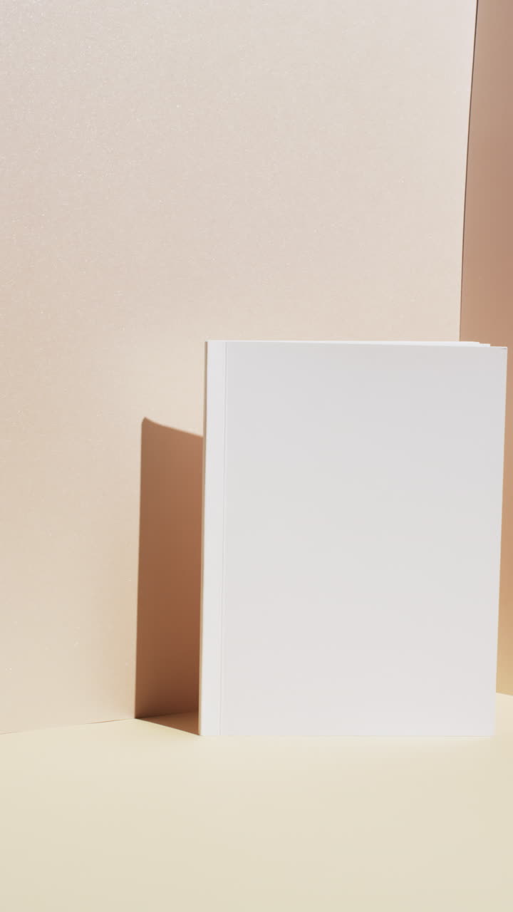 Vertical video of book with white blank pages and copy space on yellow background