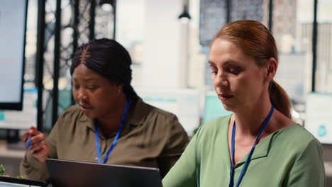vertical video determined female ceo reviews graphs and performance reports on her laptop