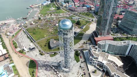 bright sunshine reflects on alphabet tower in batumi city, aerial view