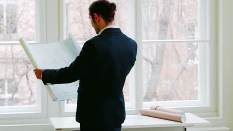 businessman looking at blueprint