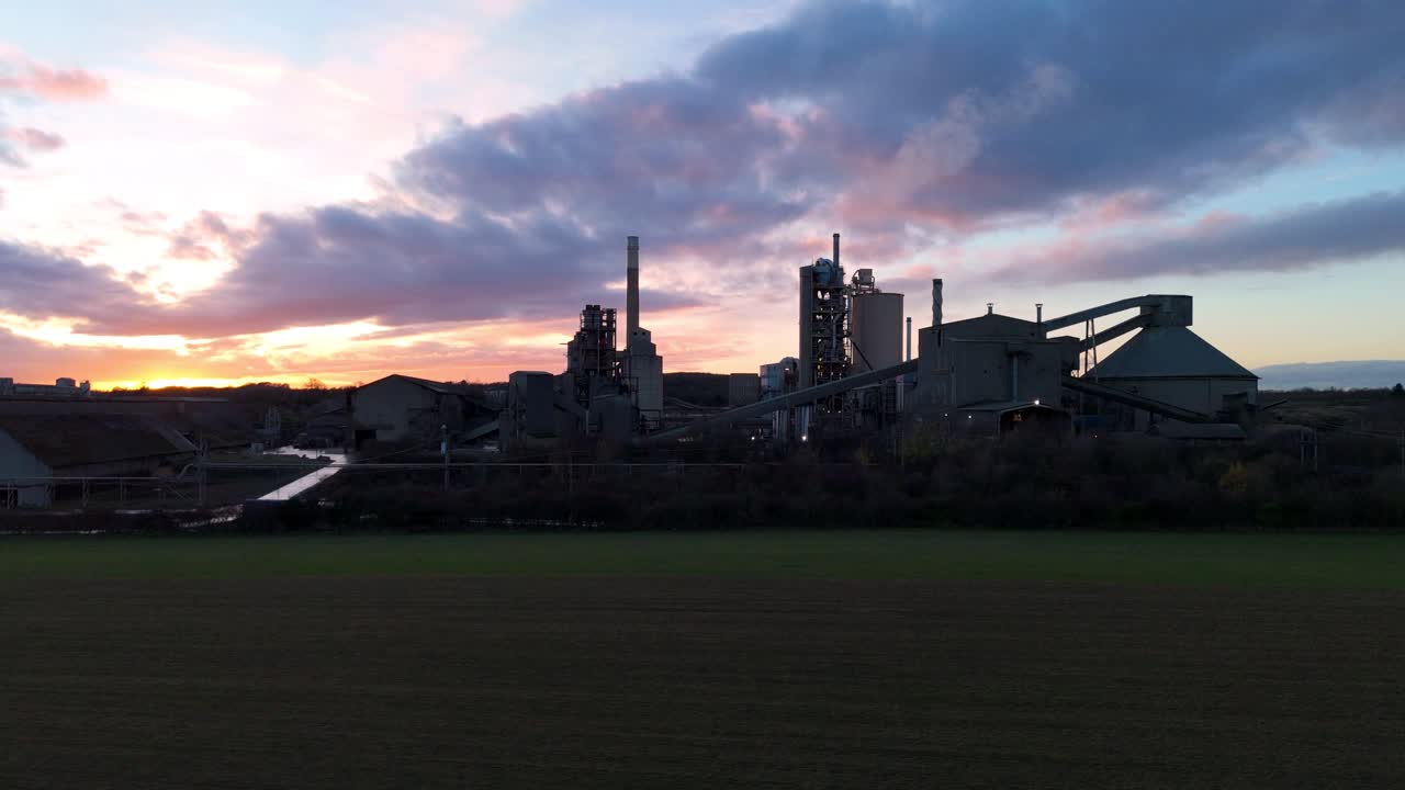 Vidstrakt fugleperspektiv af Ketton Cementværk, der viser produktionsbygninger og brudlogistik under den gyldne time.