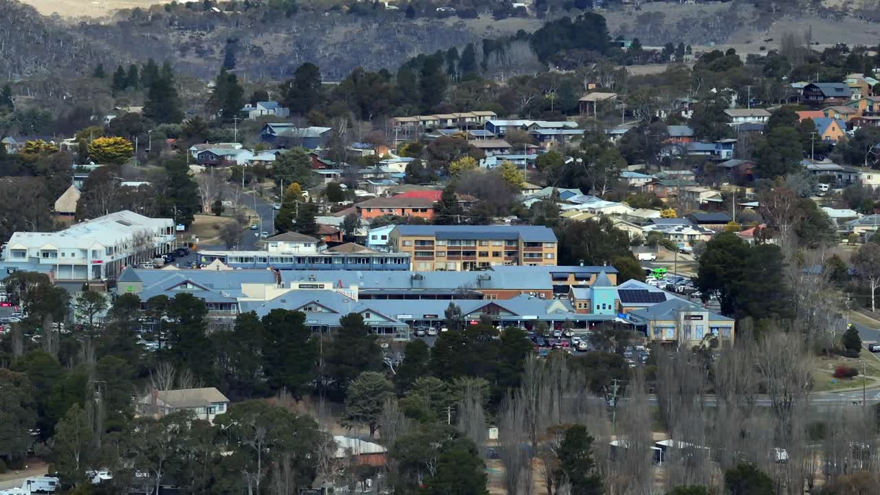 Aerial: Long lens shot of the shopping centre in Jindabyne town, NSW, Australia