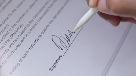 close up businessman hand working electronic signature on tablet by stylus. write business agreement of contract. man signing contract on tablet. business and technology concept.