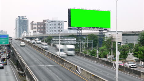 Zeitraffer-Eines-Fließenden-Verkehrs-Auf-Einer-Hauptverkehrsstraße,-Umgeben-Von-Hochhäusern-Und-Einem-Skytrain-Im-Hintergrund-In-Bangkok,-Thailand