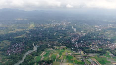 river winding through small villages of indonesia, aerial drone view