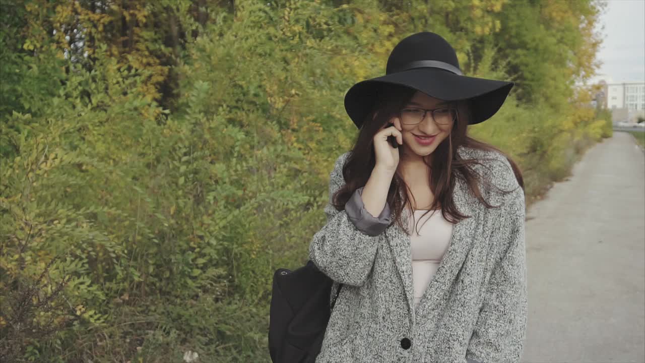 Woman Walking and Talking on Phone in Autumn Park