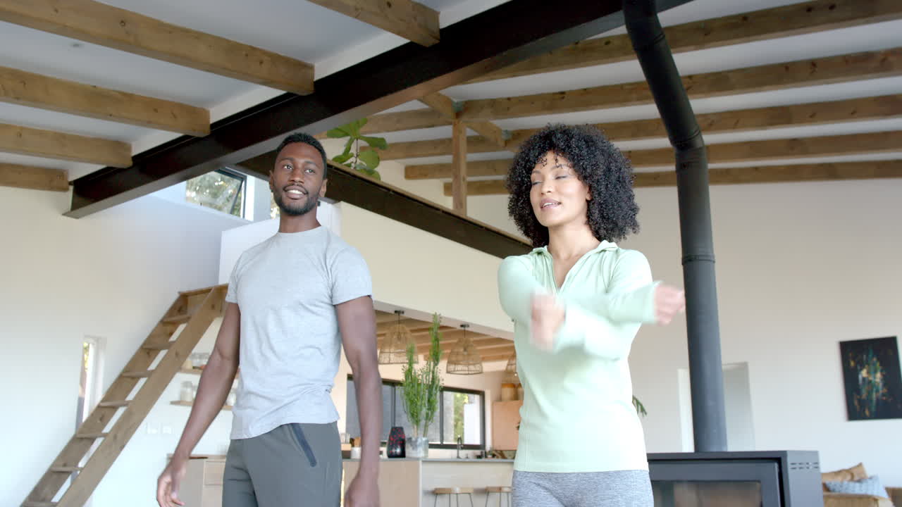 Couple enjoying morning exercise routine together in cozy living room