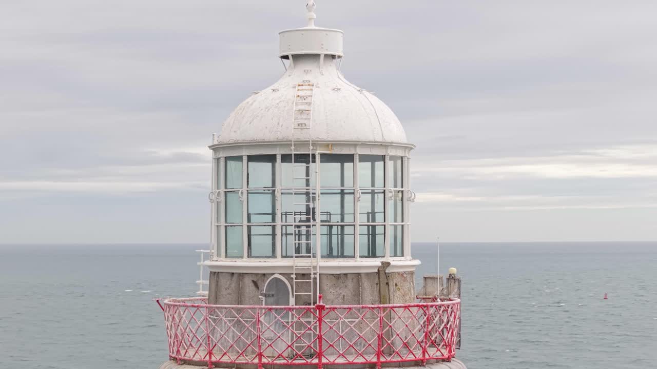 Calm view of Haulbowline Lighthouse over the sea with overcast sky