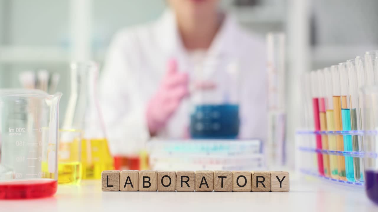 Wooden blocks spelling 'LABORATORY' in a scientific lab setting