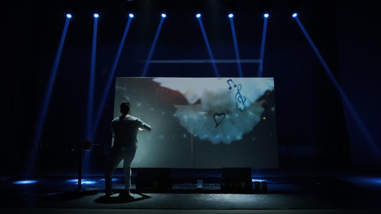 재능있는 혁신적인 예술가는 두 손을 사용하여 비디오 프로젝션으로 큰 캔버스에 그림을 그립니다. 추상적인 현대 미술을 만드는 현대 화가.