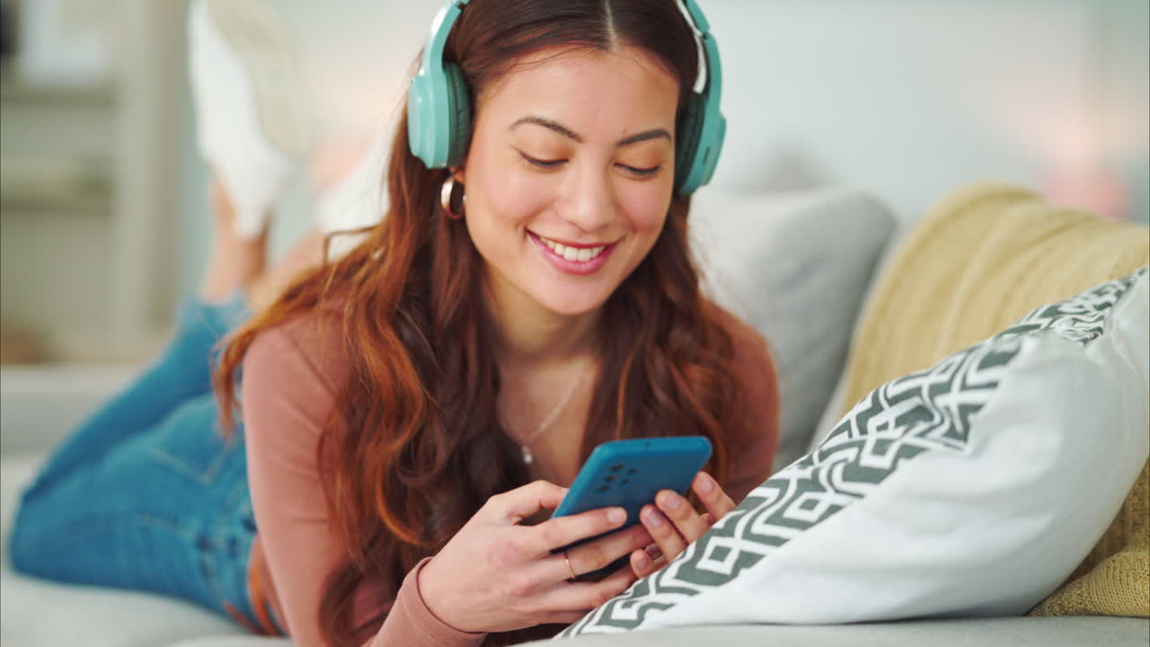 Donna che si rilassa sul divano con le cuffie e il telefono