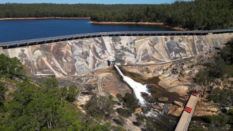 tracking aerial of giant panoramic mural painted on active dam in western australia