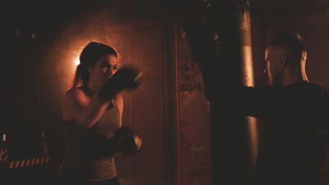 Mujer-Boxeadora-Golpea-Repetidamente-Los-Guantes-De-Su-Entrenador
