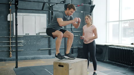 man performing box jump exercise with personal trainer
