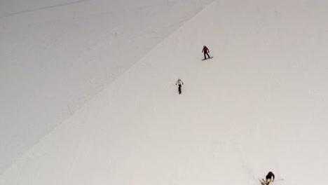 esquiadores y snowboarders en una pendiente nevada