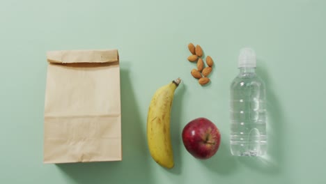 animation of paper lunch bag an fruits on blue background