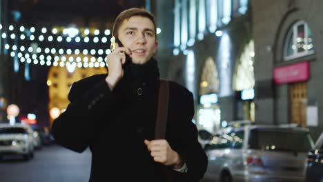 Young-man-talking-on-the-phone-against-the-backdrop-of-a-night-city-4