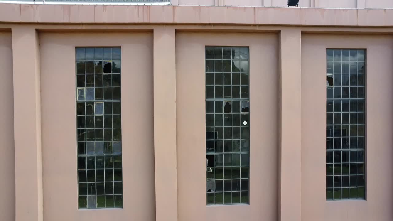 volando hacia arriba y acercándose a la abandonada, en desuso, abandonada fábrica de almacenes de la central eléctrica art deco en el este de perth y hacia arriba y hacia el horizonte de perth