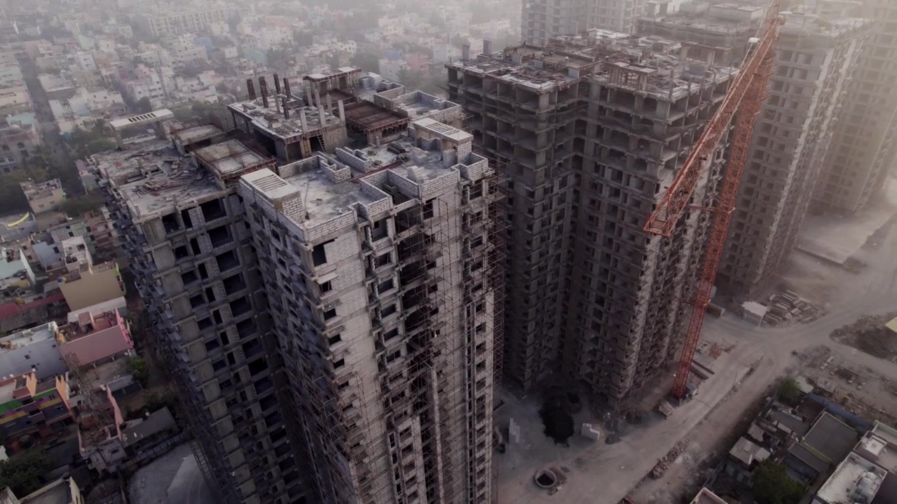 Vista aérea de grúas de construcción y un amanecer con niebla en el estado sureño de Tamil Nadu, India