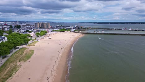 aerial view of urban beach and coastal city with long bridge